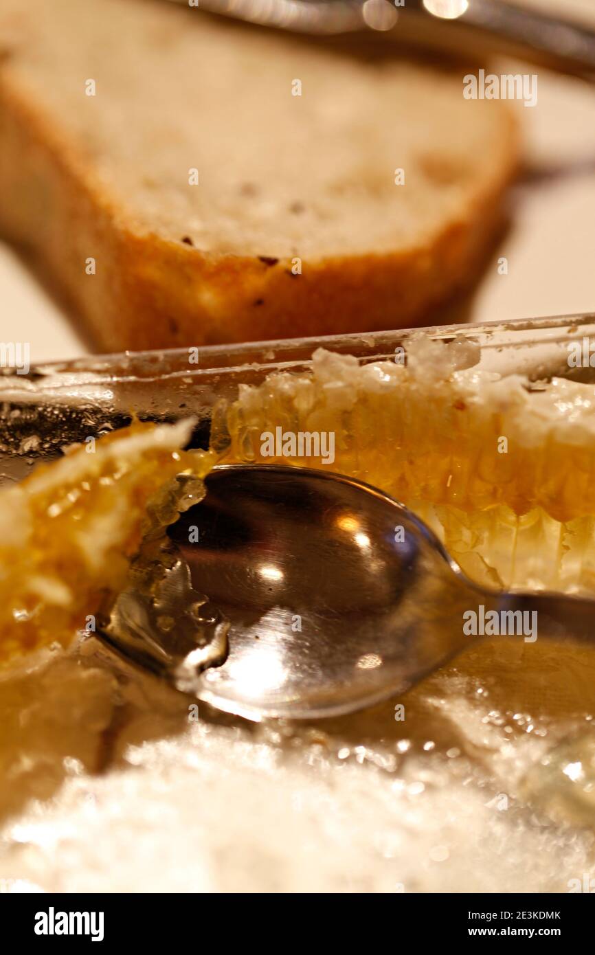 Primo piano del cucchiaio in nido d'ape, tagliare miele a pettine. Un cucchiaio di miele. Foto Stock