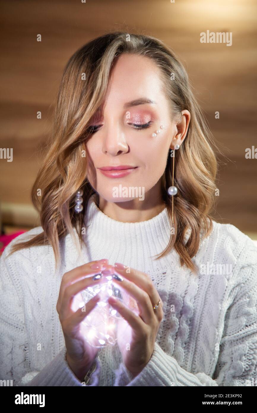 Ritratto di Capodanno di una ragazza con luci in lei mani Foto Stock