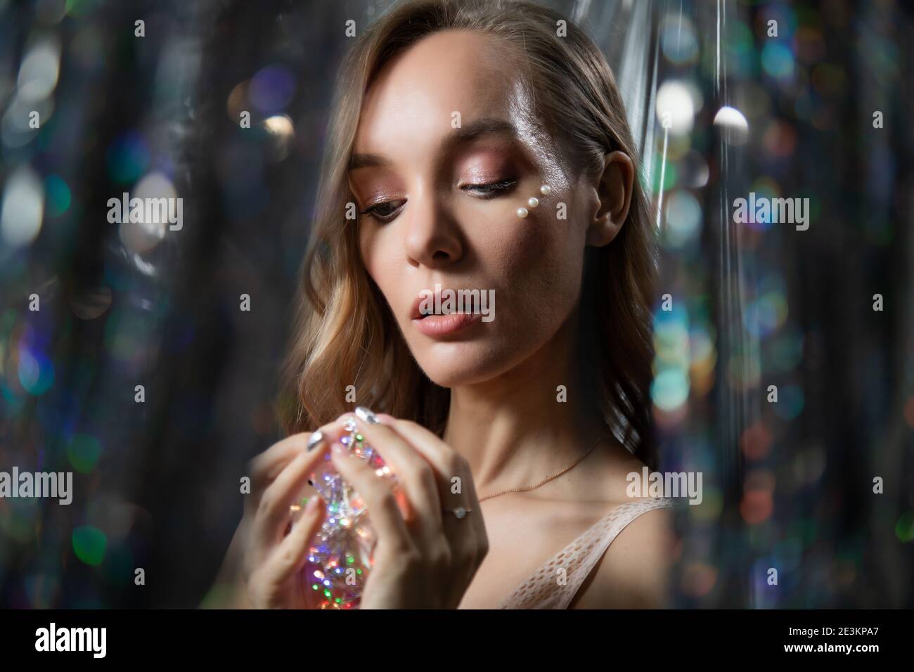 Ritratto di Capodanno di una ragazza con luci in lei mani Foto Stock