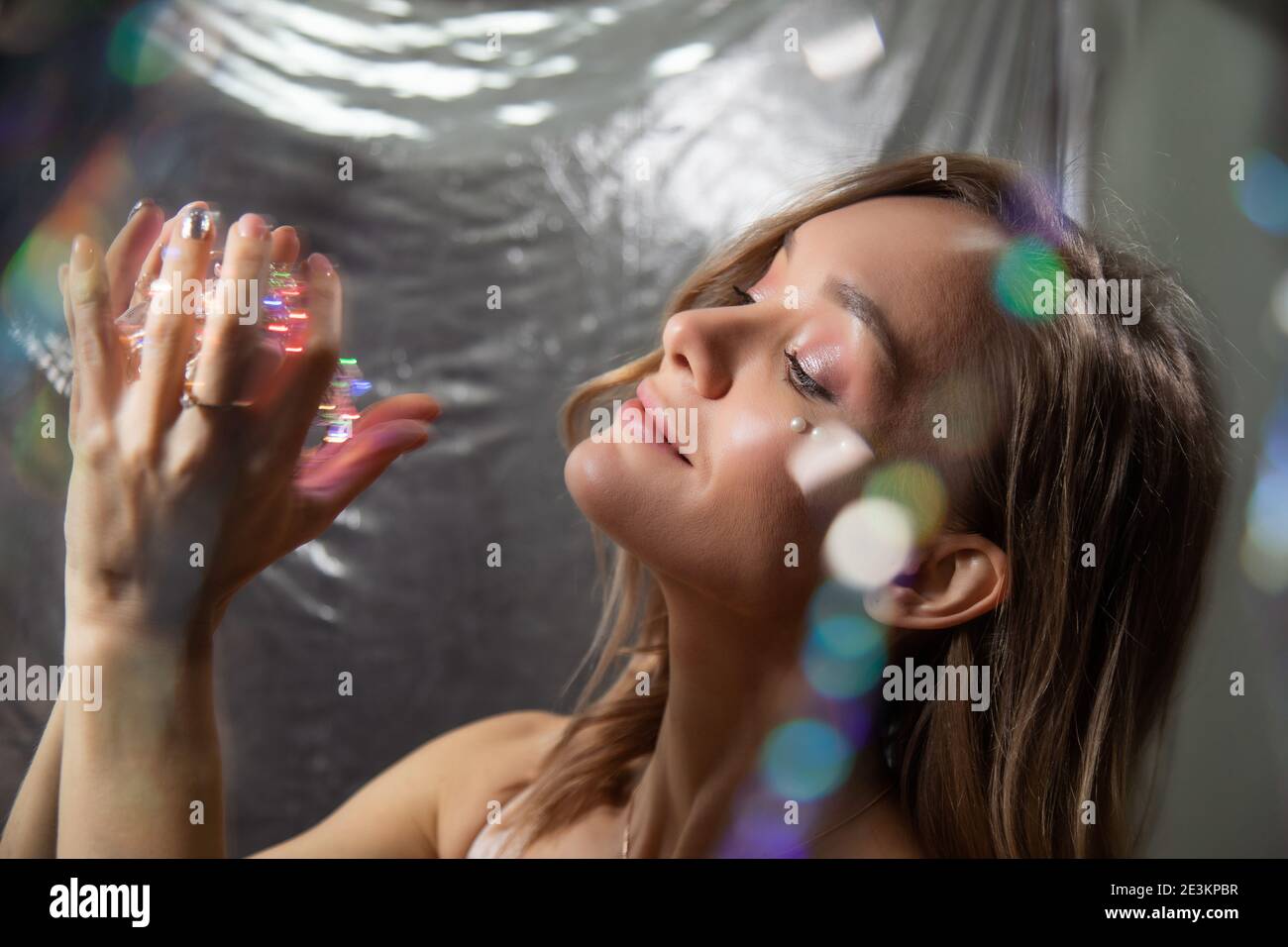 Ritratto di Capodanno di una ragazza con luci in lei mani Foto Stock
