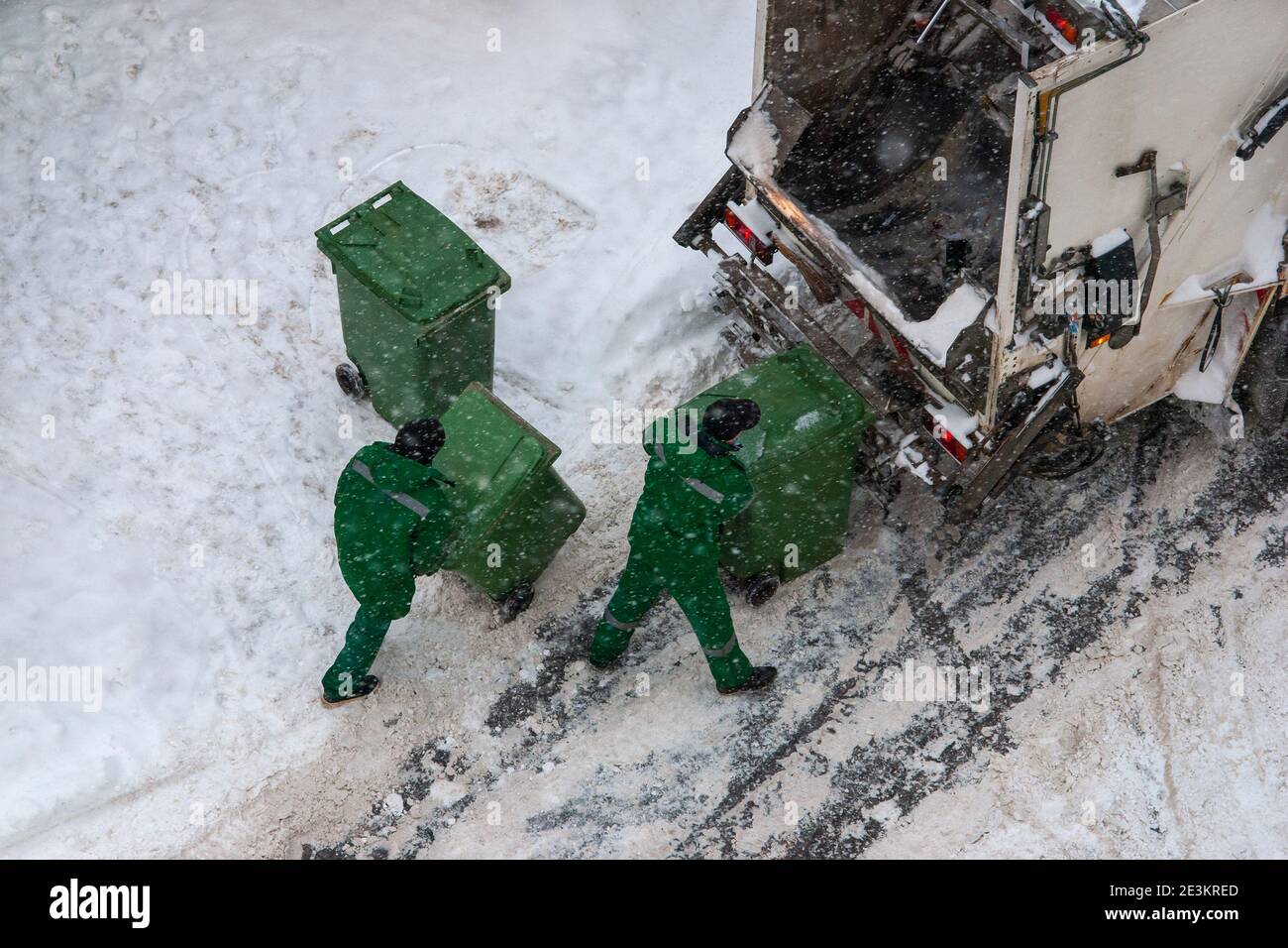 i lavoratori addetti alla raccolta dei rifiuti raccoliscono i rifiuti domestici in inverno Foto Stock