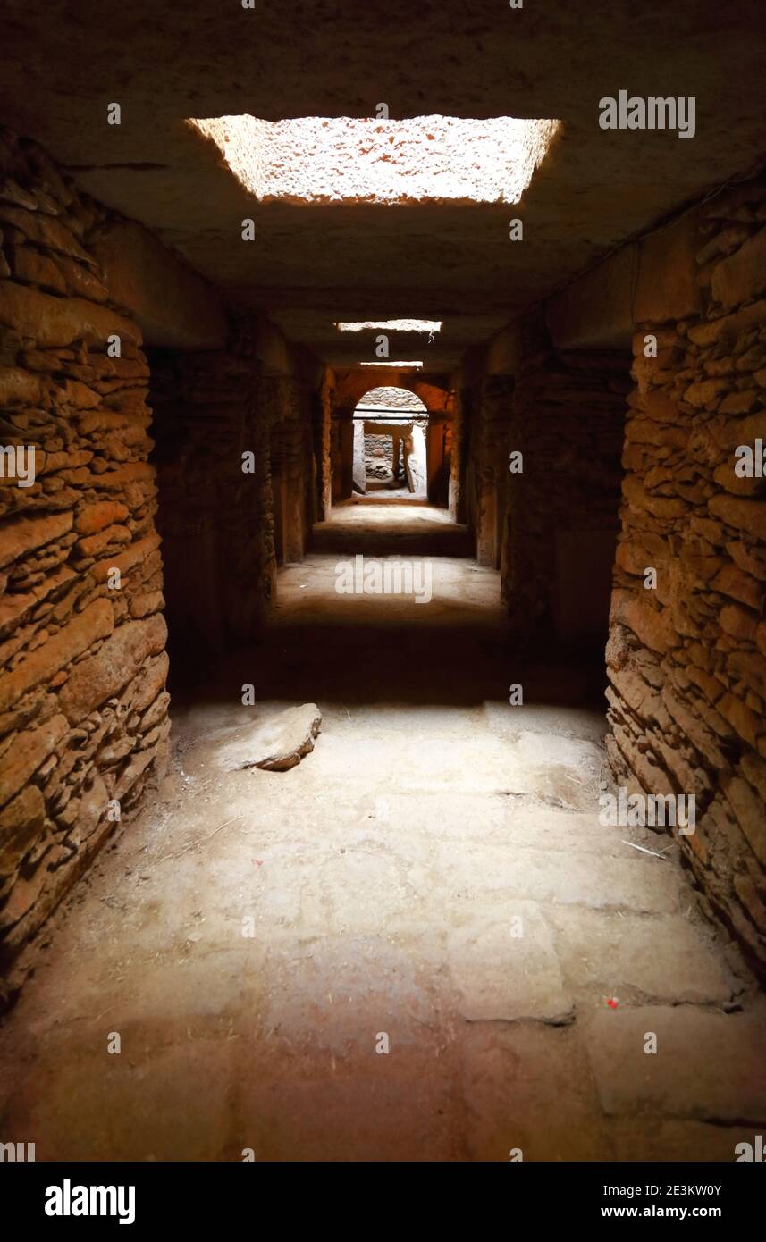 Pareti di pietra ruvida formano un tunnel che collega le camere della tomba sotto le stele di Aksum, la luce naturale che entra dall'alto attraverso i camini tagliati al s. Foto Stock