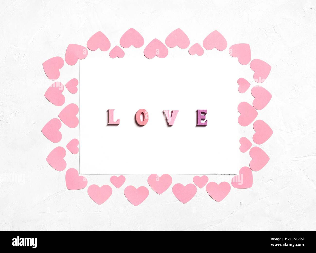 Biglietto d'auguri per San Valentino con cuori rosa e l'iscrizione amore. Giorno di San Valentino, concetto di giorno delle madri. Vista dall'alto. Foto Stock