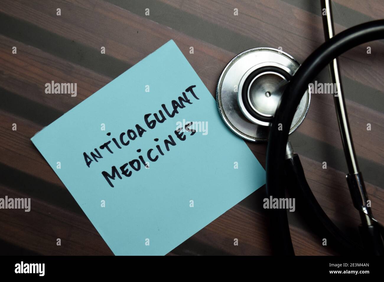 Le medicine anticoagulanti scrivono sulle note appiccicose isolate sulla tavola di legno. Foto Stock