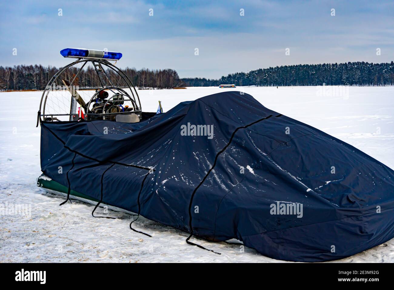 Autopotere della polizia o veicolo a cuscino d'aria o ACV sotto tenda, poliziotti in primo piano su una motoslitta, polizia fuoristrada in inverno, aria Foto Stock