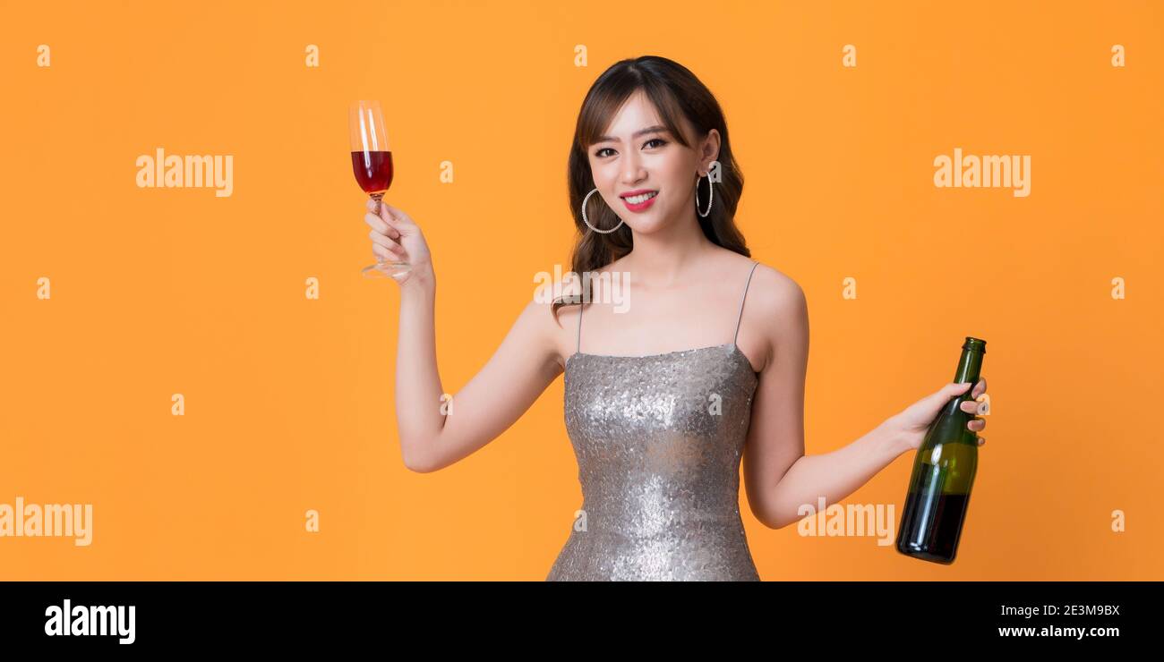 Giovane donna attraente in abito da sera che tiene un bicchiere di champagne, tempo di festa Foto Stock