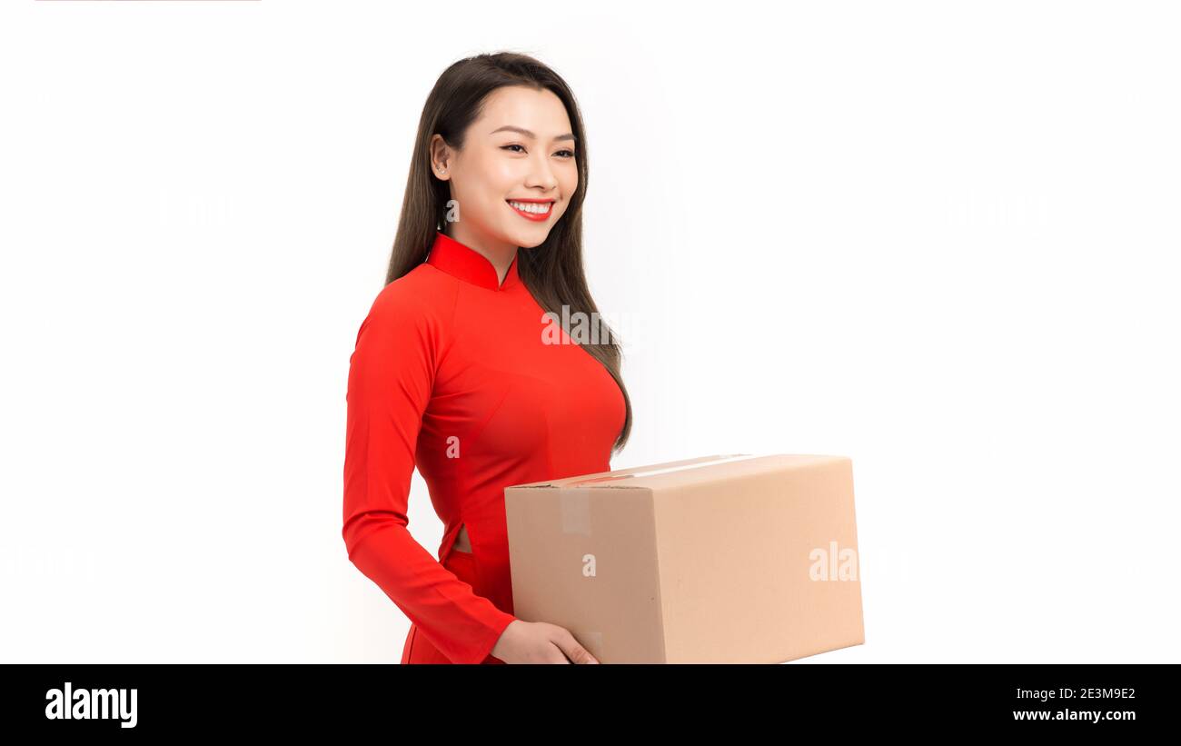 Bella giovane donna sorridente che tiene presente avvolto in un involucro dorato carta augurano ai giovani un felice anno nuovo Foto Stock