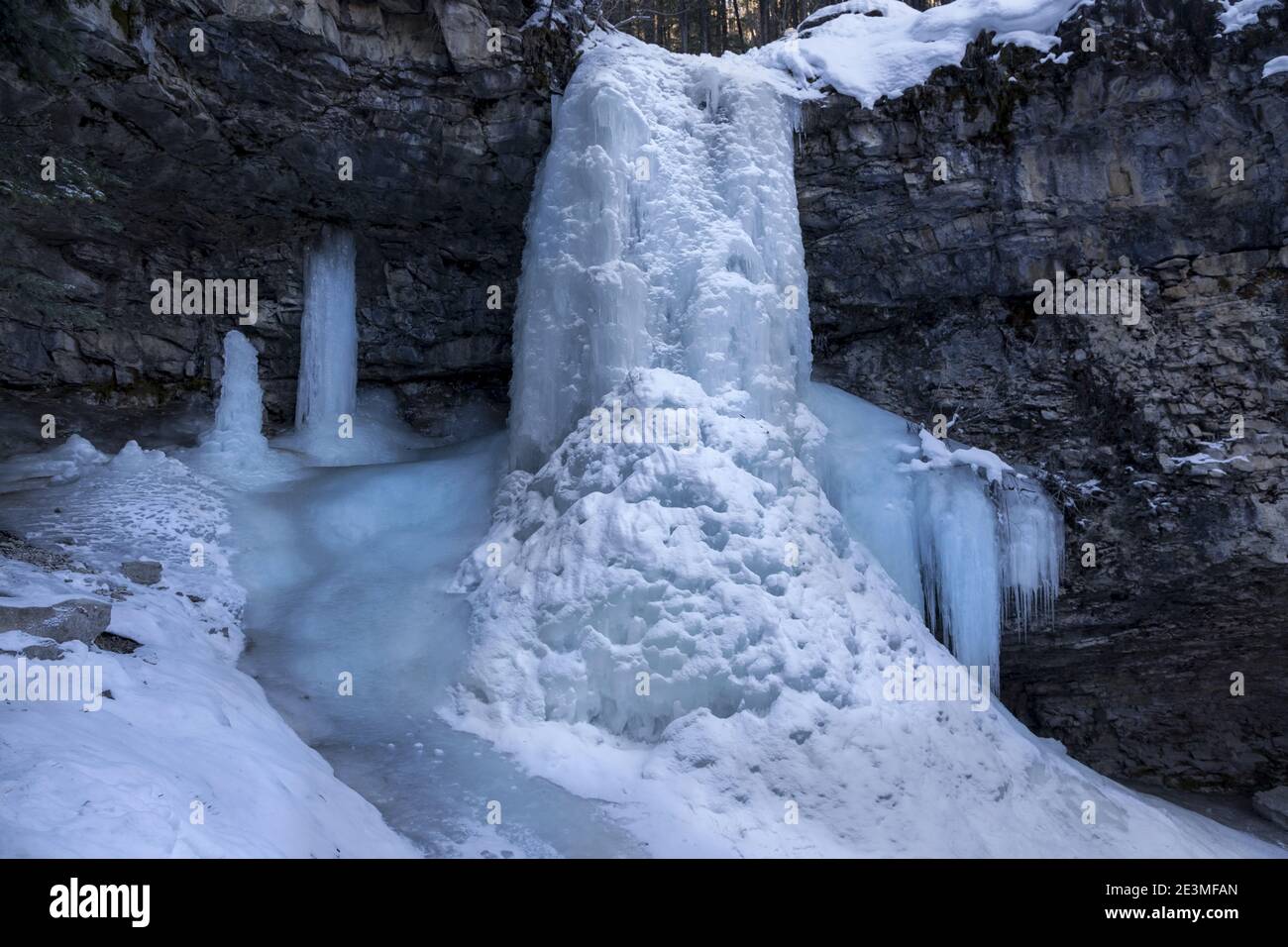 Troll Falls, una cascata di ghiaccio ghiacciata nella Rock Cave. Giornata invernale fredda paesaggio panoramico a Kananaskis Country, Alberta, Montagne Rocciose canadesi Foto Stock