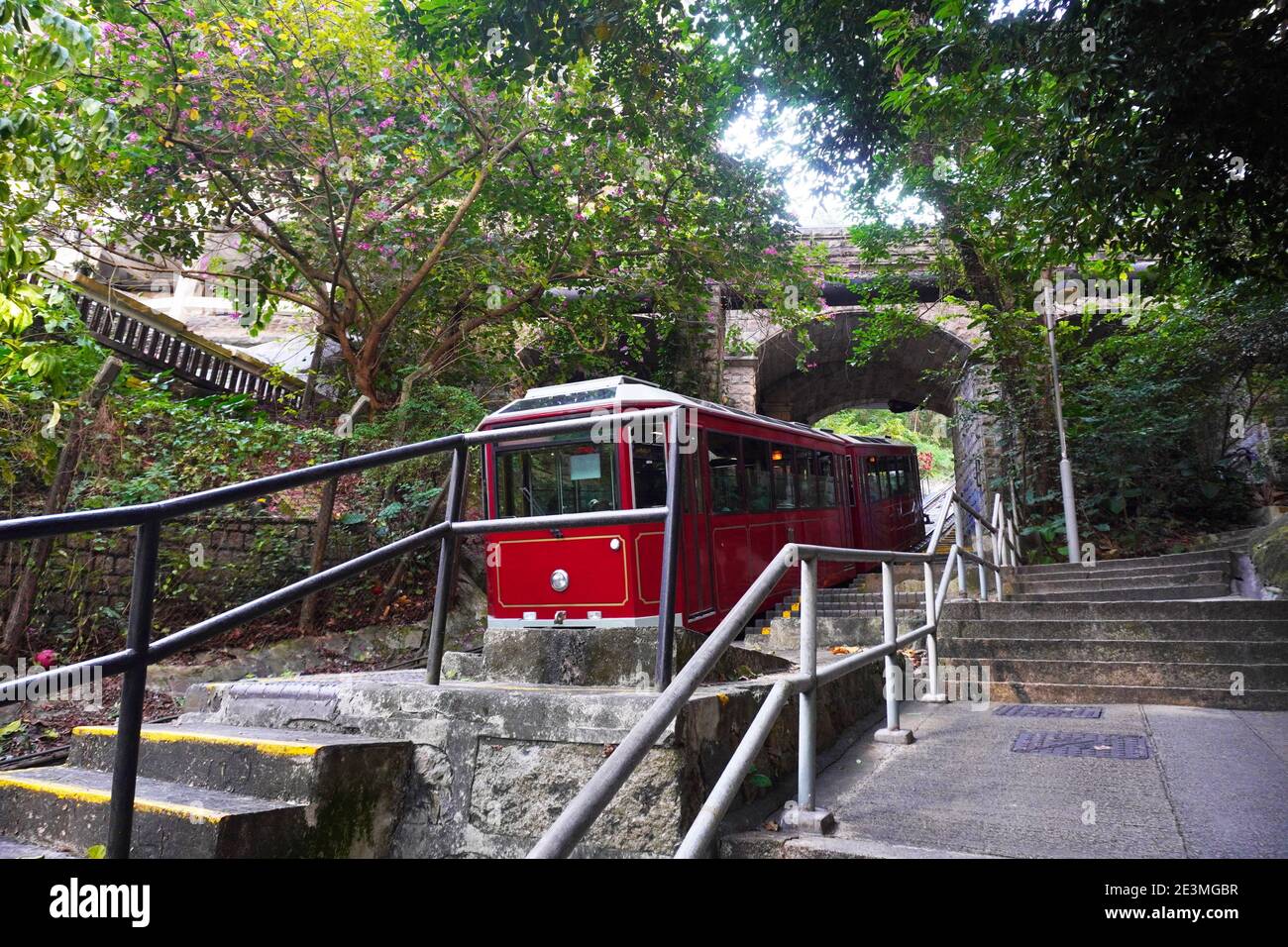 Il Peak Tram di Hong Kong che attraversa il fondo del ponte. Scatto medio, vista a livello dell'occhio Foto Stock