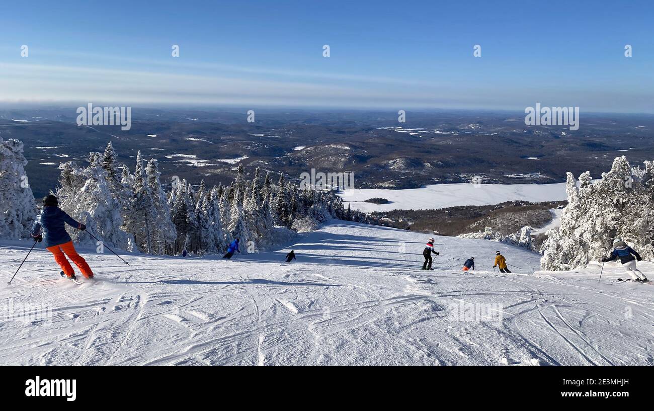 Vista panoramica aerea di Mont Tremblant e del lago in inverno con sciatori su discese in discesa, Quebec, Canada Foto Stock