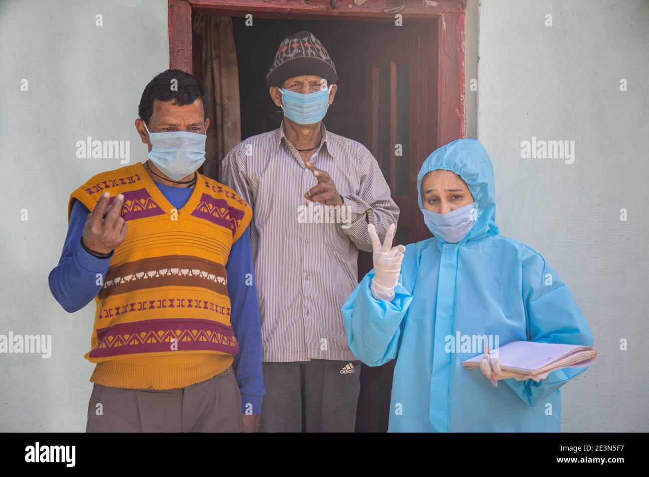 Donne infermieri lavoratori in kit ppe facendo porta a porta Indagini nel villaggio indiano per quanto riguarda Covid-19 Foto Stock