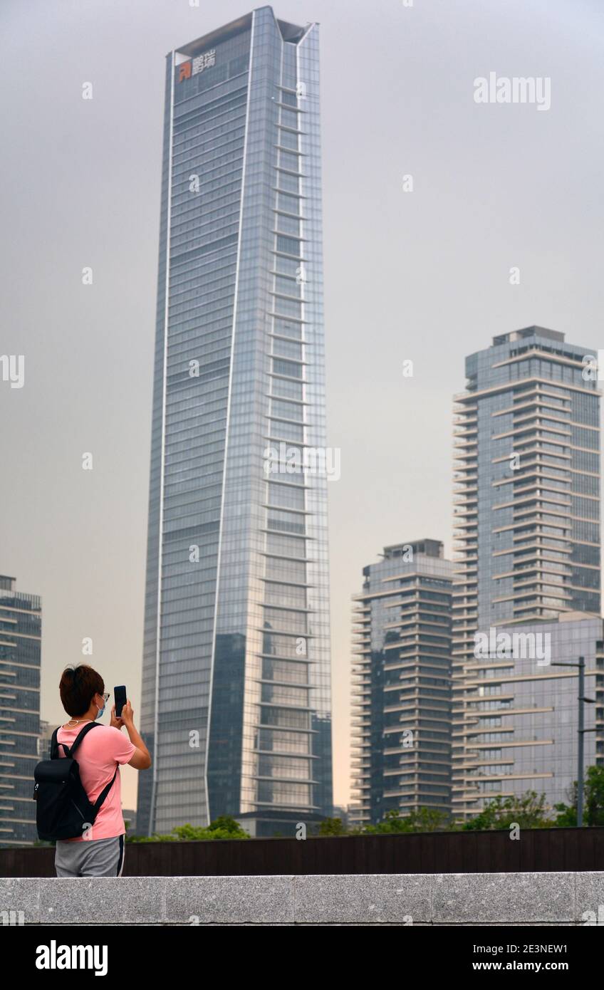 Fotografare il fotografo. Giovane donna che scattava delle istantanee davanti a me mentre stavo fotografando i grattacieli e la tempesta incombente. Foto Stock