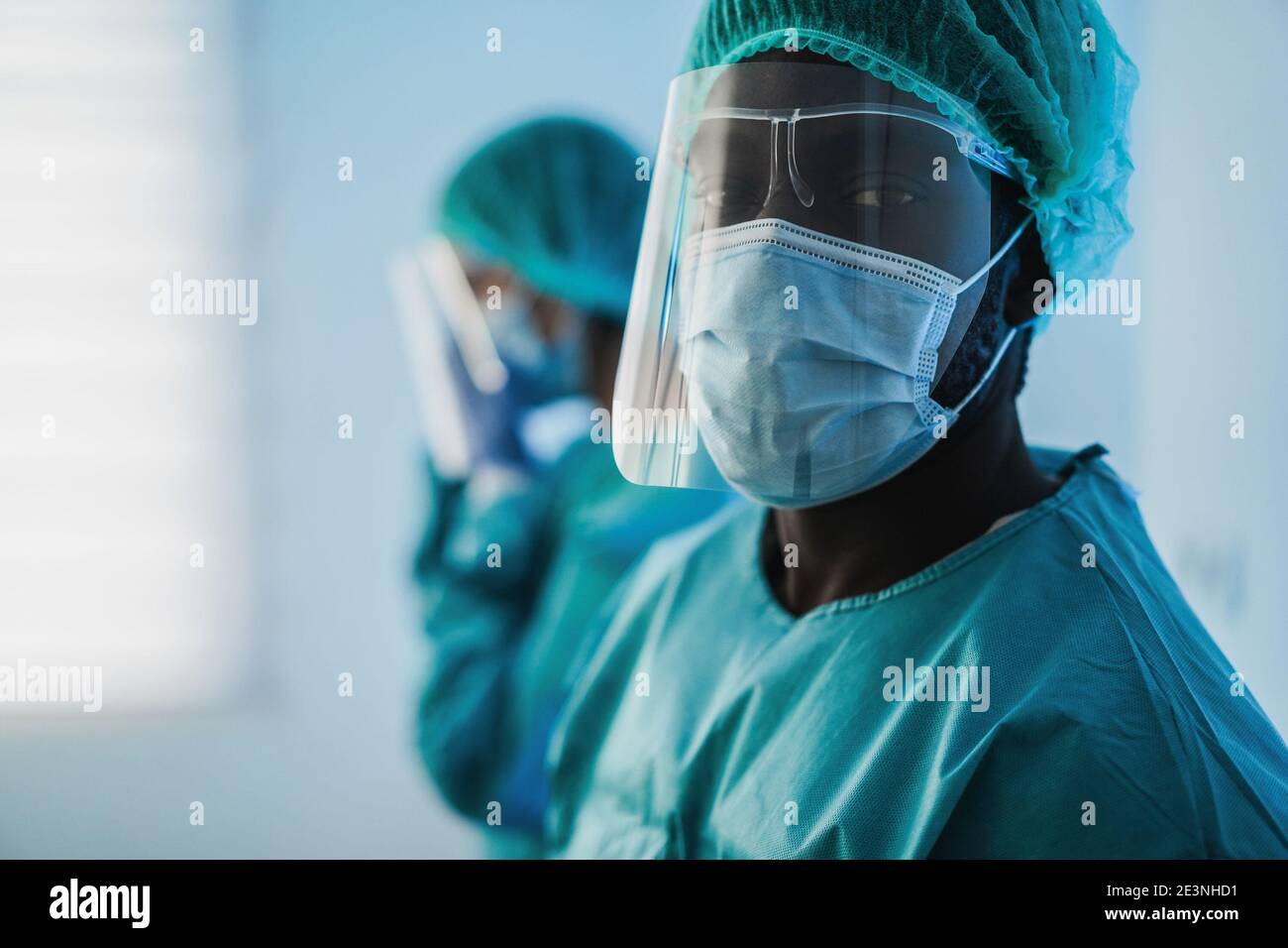 Uomini medici al lavoro all'interno dell'ospedale durante l'epidemia di coronavirus - Medico lavoratore su Covid-19 crisi indossare maschera di protezione del viso - Mettere a fuoco sulla maschera Foto Stock