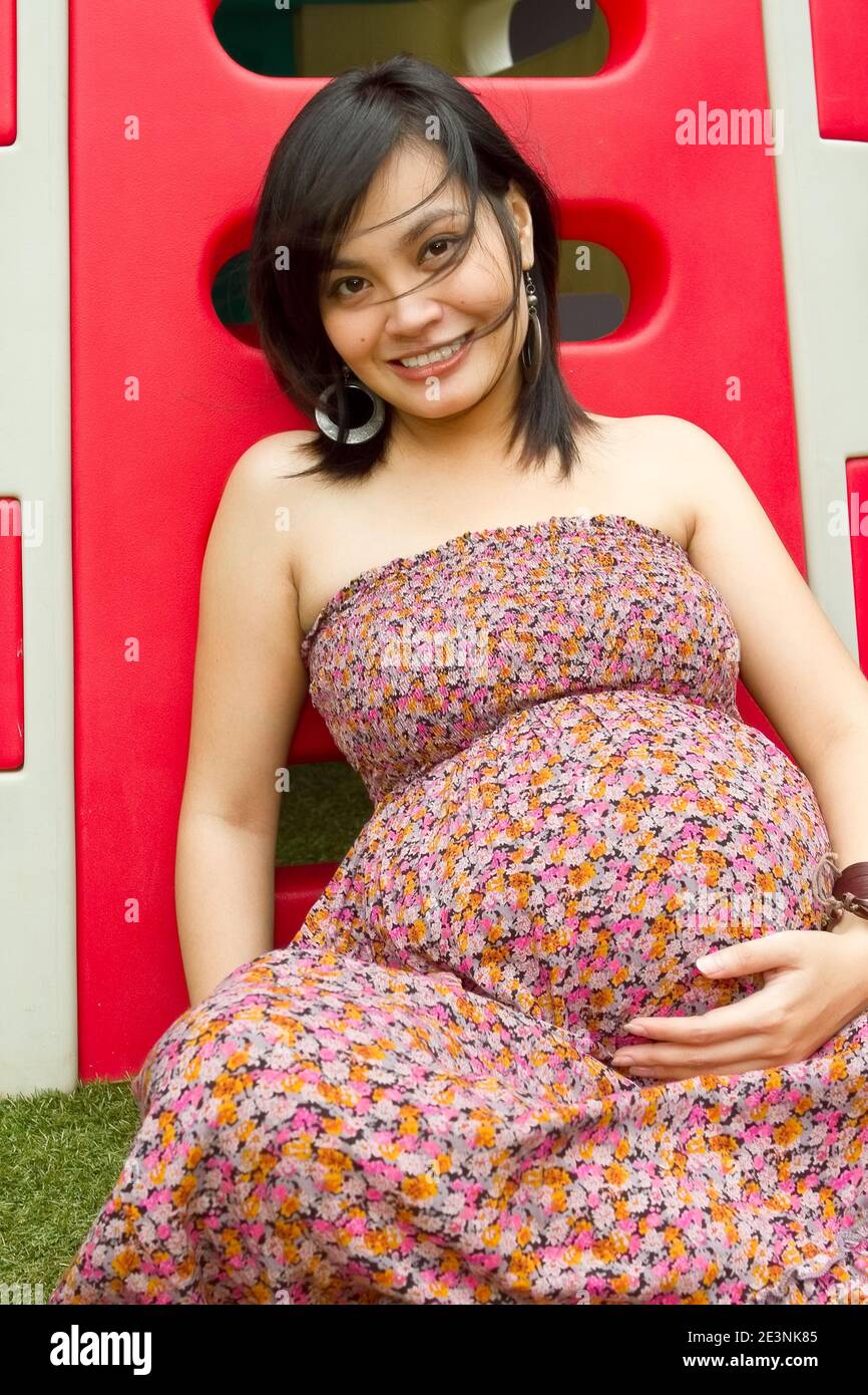 Ritratto di sana donna incinta etnica asiatica al parco giochi Foto Stock
