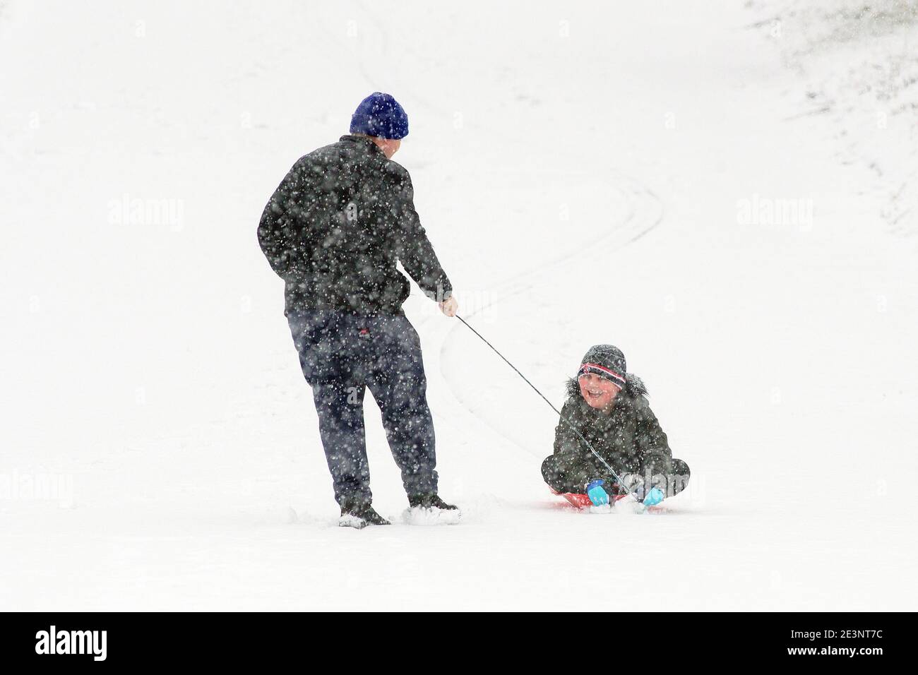 Una slitta di padre e figlio a Barnsley, nello Yorkshire meridionale. Foto Stock