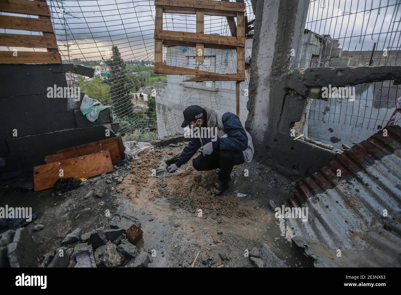 Deir al Balah, territori palestinesi. 20 gennaio 2021. Un poliziotto palestinese della squadra di lotta contro gli esplosivi ispeziona le macerie di una casa distrutta ad est del campo profughi di al-Maghazi, vicino alla recinzione di confine con Israele, nella striscia centrale di Gaza. I carri armati israeliani hanno colpito i posti militari di Hamas nel sud della striscia di Gaza martedì sera dopo che i militanti palestinesi hanno sparato un proiettile nel territorio israeliano. Credit: Mohammed Talatene/dpa/Alamy Live News Foto Stock