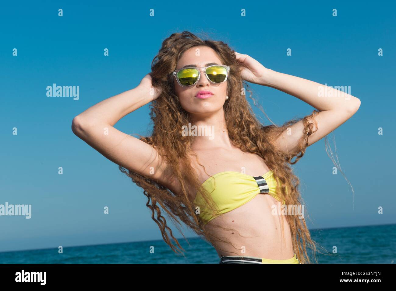 donna bionda con lunghi capelli ricci godendo il mare dentro primavera o estate Foto Stock