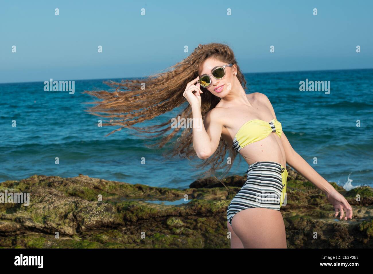 donna bionda con lunghi capelli ricci godendo il mare dentro primavera o estate Foto Stock