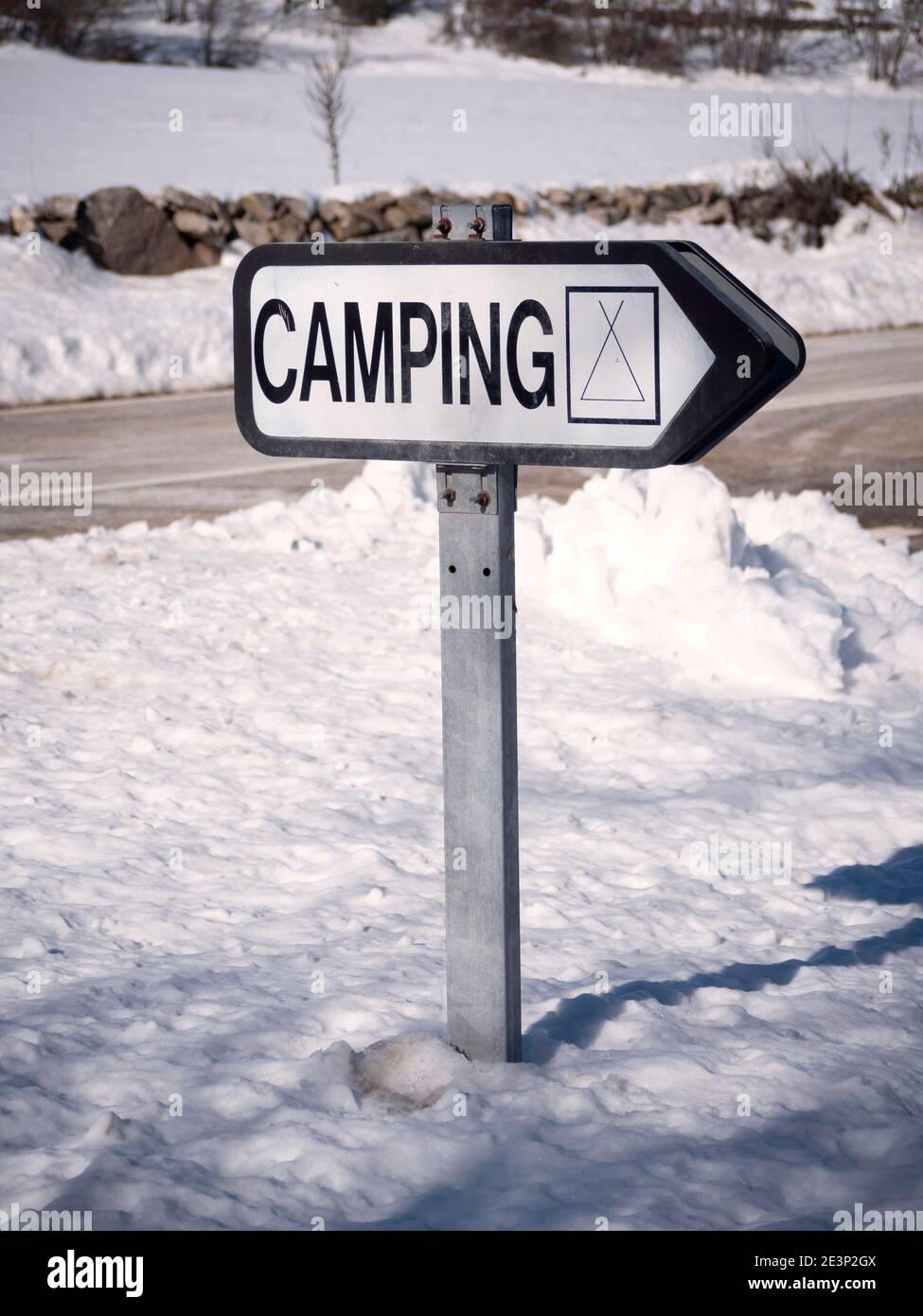Cartello campeggiare e strada in uno sfondo innevato invernale. Foto Stock