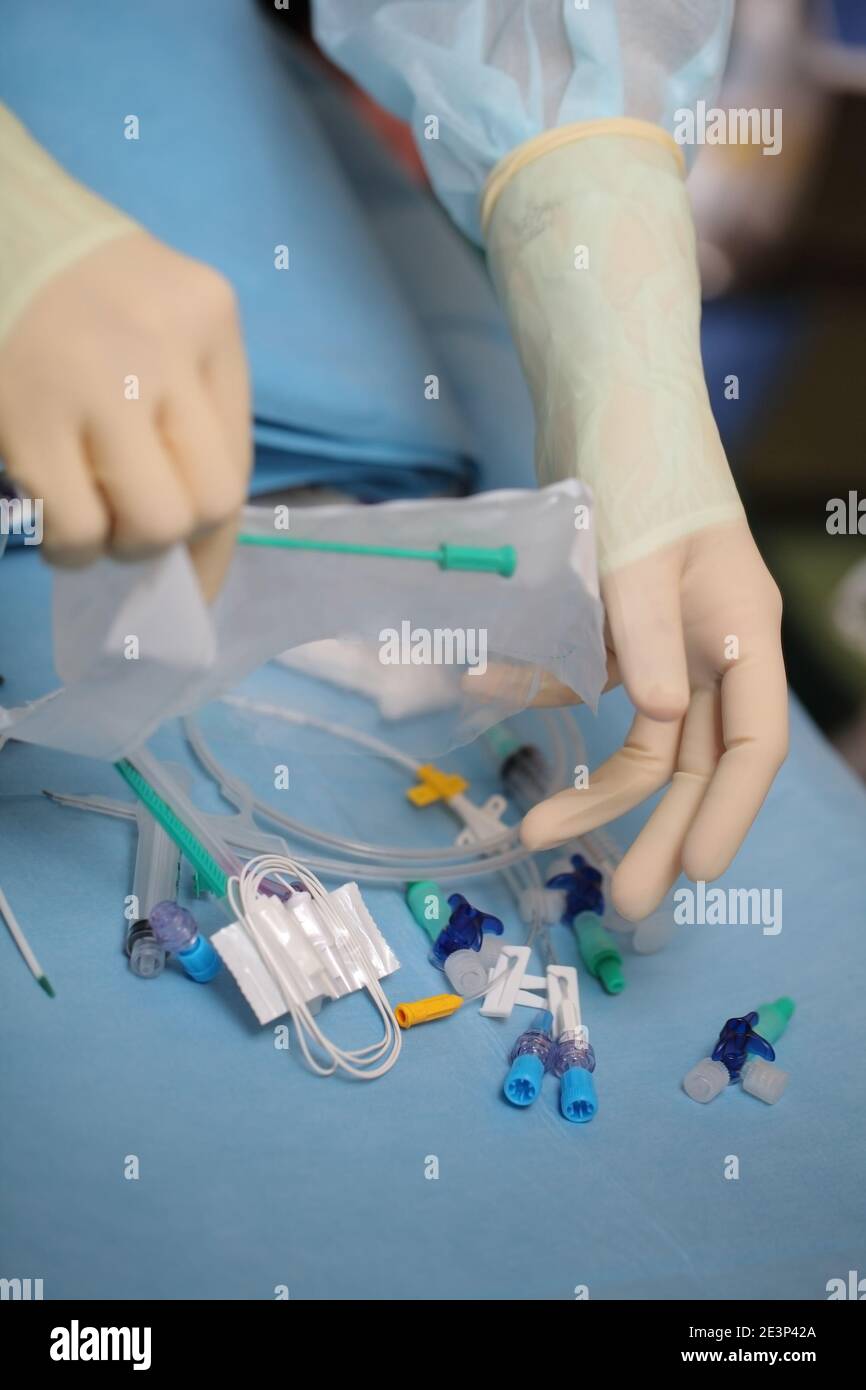 Il medico ha aperto la confezione di strumenti di cateterizzazione durante la preparazione alla narcosi prima dell'intervento chirurgico. Foto Stock