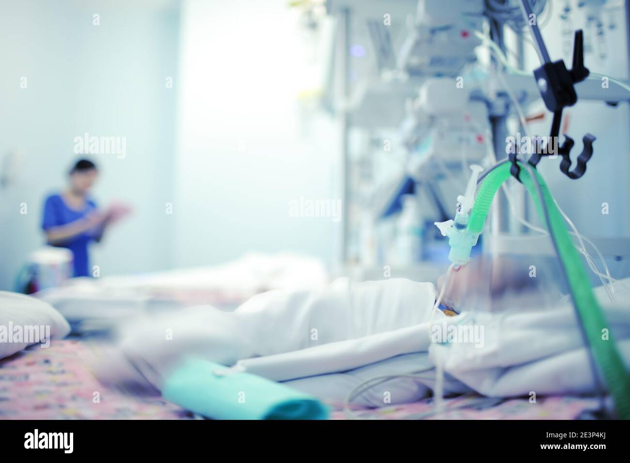 Bambino che respira pesante con l'aiuto dell'apparecchio e dell'ossigeno in un letto dell'ospedale nella moderna NICU. Foto Stock