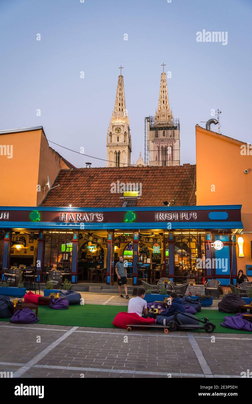 Persone sedute in comodi beanbags di fronte all'Harat's Pub, pub irlandese, Zagabria, Croazia Foto Stock