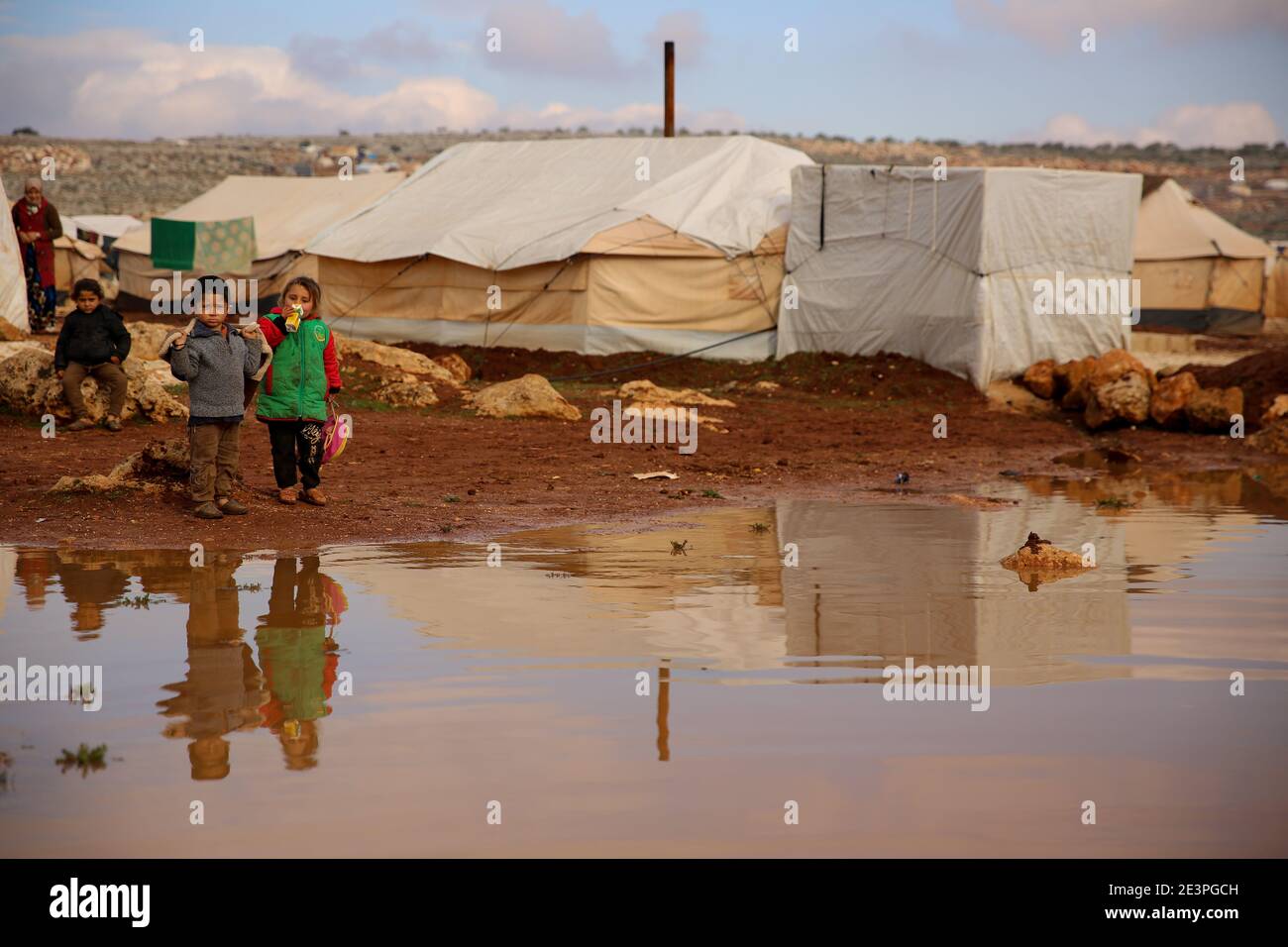 19 gennaio 2021: Idlib, Siria. 19 gennaio 2021. I bambini sono esposti alle dure condizioni meteorologiche e alle inondazioni in un campo per sfollati interni siriani intorno al villaggio di Killi nella provincia di Idlib. Le inondazioni hanno aggiunto ulteriori sfide alle famiglie sfollate nel nord-ovest della Siria che già si trovano ad affrontare temperature invernali che talvolta raggiungono sotto i zero gradi Celsius di notte. Molte famiglie nel campo erano fuggite dagli attacchi delle forze governative siriane e del loro alleato russo, e potrebbero non essere disposte a tornare nelle loro città perché le loro case e villaggi sono stati distrutti o Foto Stock