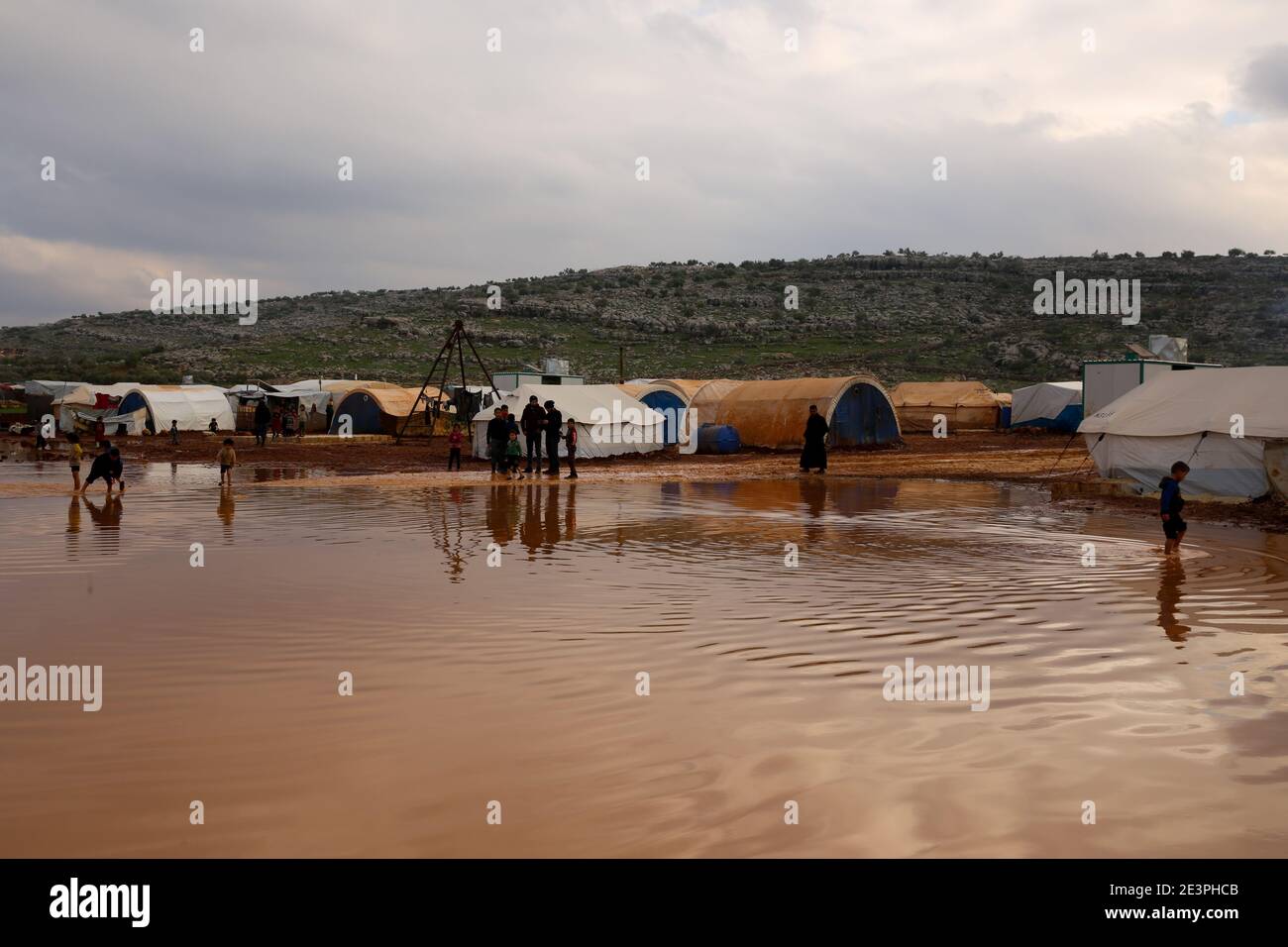 19 gennaio 2021: Idlib, Siria. 19 gennaio 2021. I bambini sono esposti alle dure condizioni meteorologiche e alle inondazioni in un campo per sfollati interni siriani intorno al villaggio di Killi nella provincia di Idlib. Le inondazioni hanno aggiunto ulteriori sfide alle famiglie sfollate nel nord-ovest della Siria che già si trovano ad affrontare temperature invernali che talvolta raggiungono sotto i zero gradi Celsius di notte. Molte famiglie nel campo erano fuggite dagli attacchi delle forze governative siriane e del loro alleato russo, e potrebbero non essere disposte a tornare nelle loro città perché le loro case e villaggi sono stati distrutti o Foto Stock