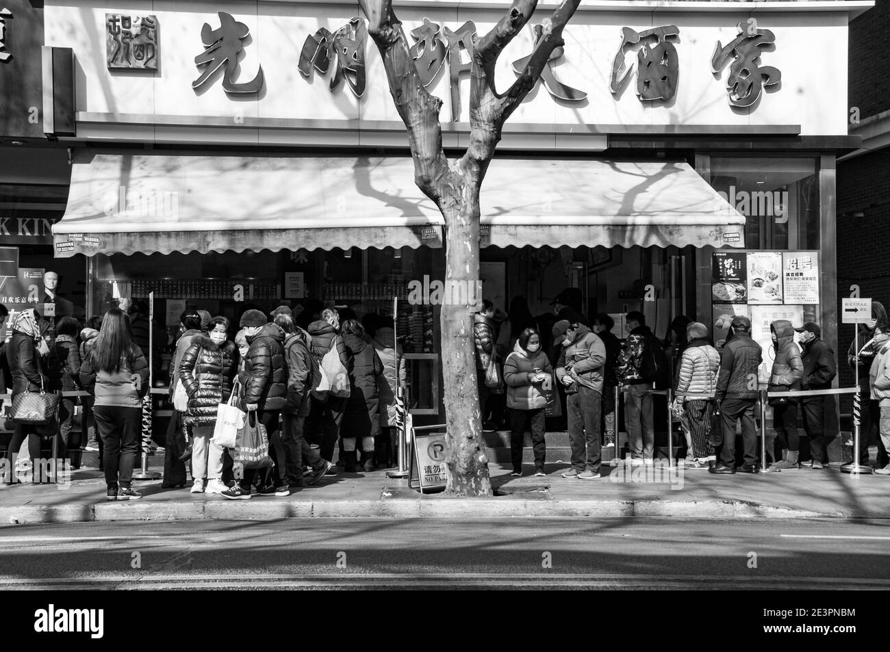 Lunghe code di residenti che acquistano cibi tradizionali per il cinese nuovo Anno in un famoso negozio di alimentari nel centro di Huai Hai Strada una delle principali vie dello shopping Foto Stock