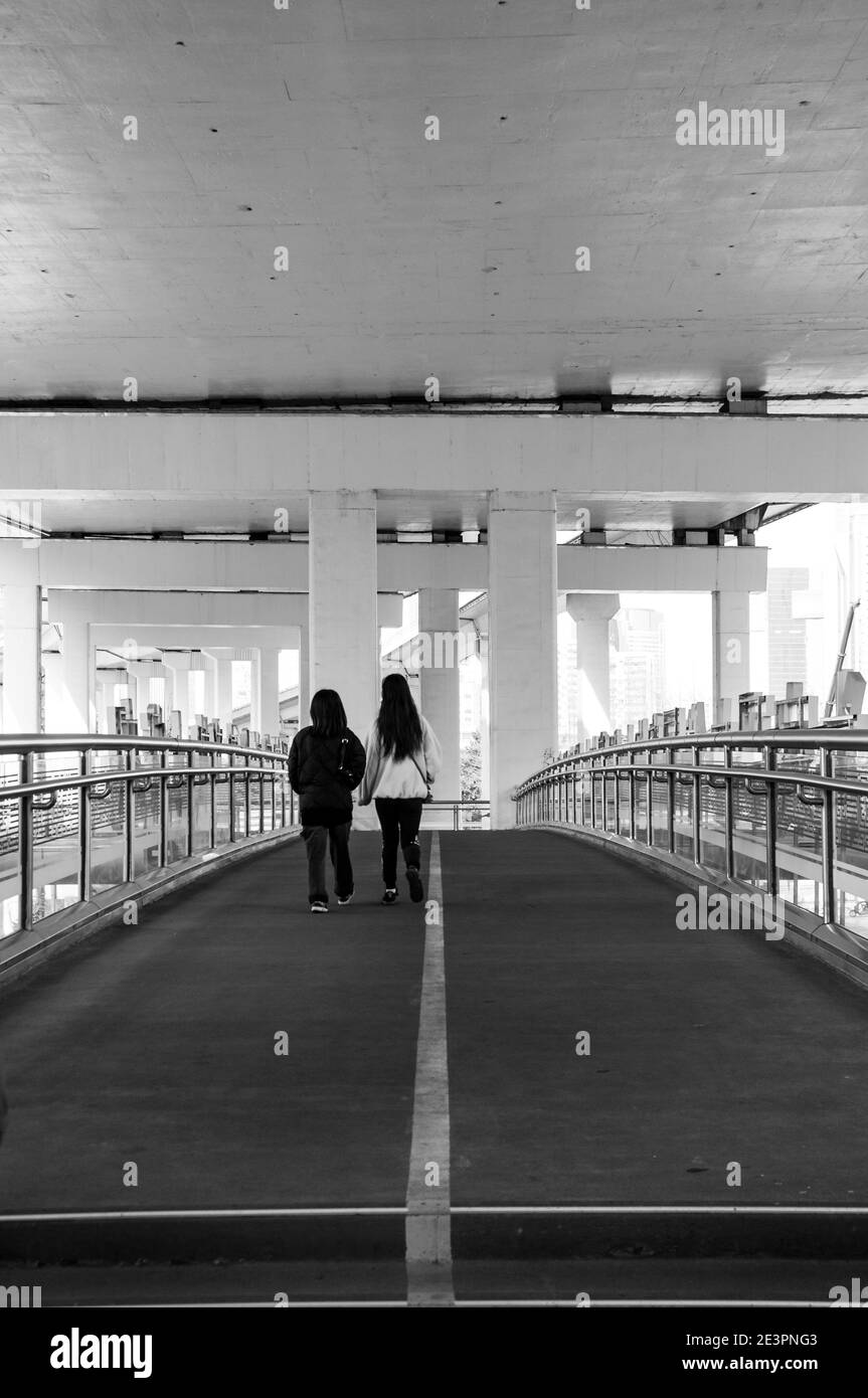 Le persone che attraversano il ponte pedonale sulla Chongqing South Road intorno al centro di Huai Hai Road, una delle principali vie dello shopping a Shanghai. Foto Stock