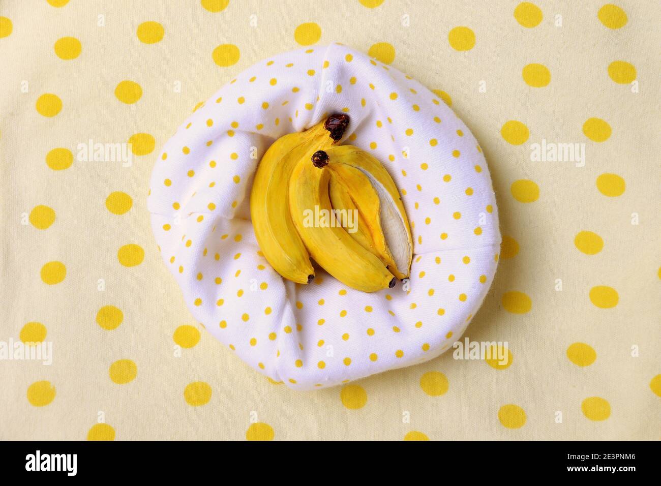 Una miniatura in resina di banana su uno sfondo da picnic punteggiato. Foto Stock