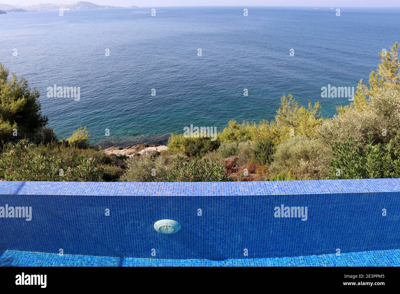 Piscina circondata da alberi sul mare blu e sullo sfondo della baia. Spiaggia relax e vacanza, godendo di concetto di vita Foto Stock