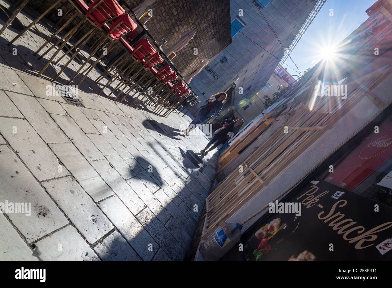 Due giovani donne che camminano in una stretta strada pedonale con caffè all'aperto, Zara, Dalmazia, Croazia Foto Stock