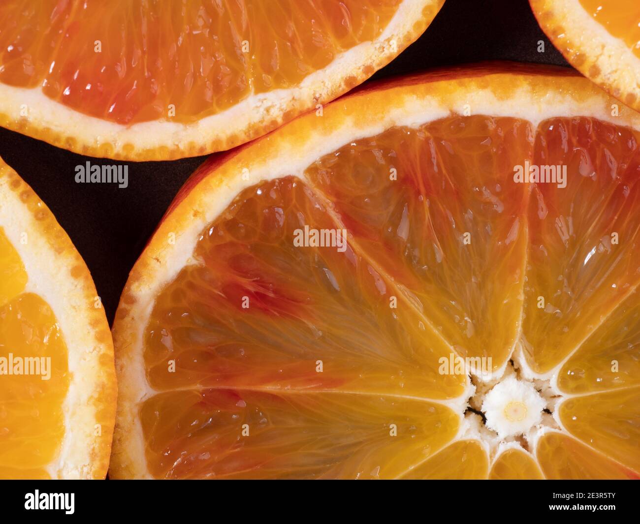 Colorato frutta sfondo vista dall'alto. Fette di arancio rosso sono su piatto scuro. Vista dall'alto dello sfondo arancione. Agrumi freschi ricchi di vitamine, succosa Foto Stock