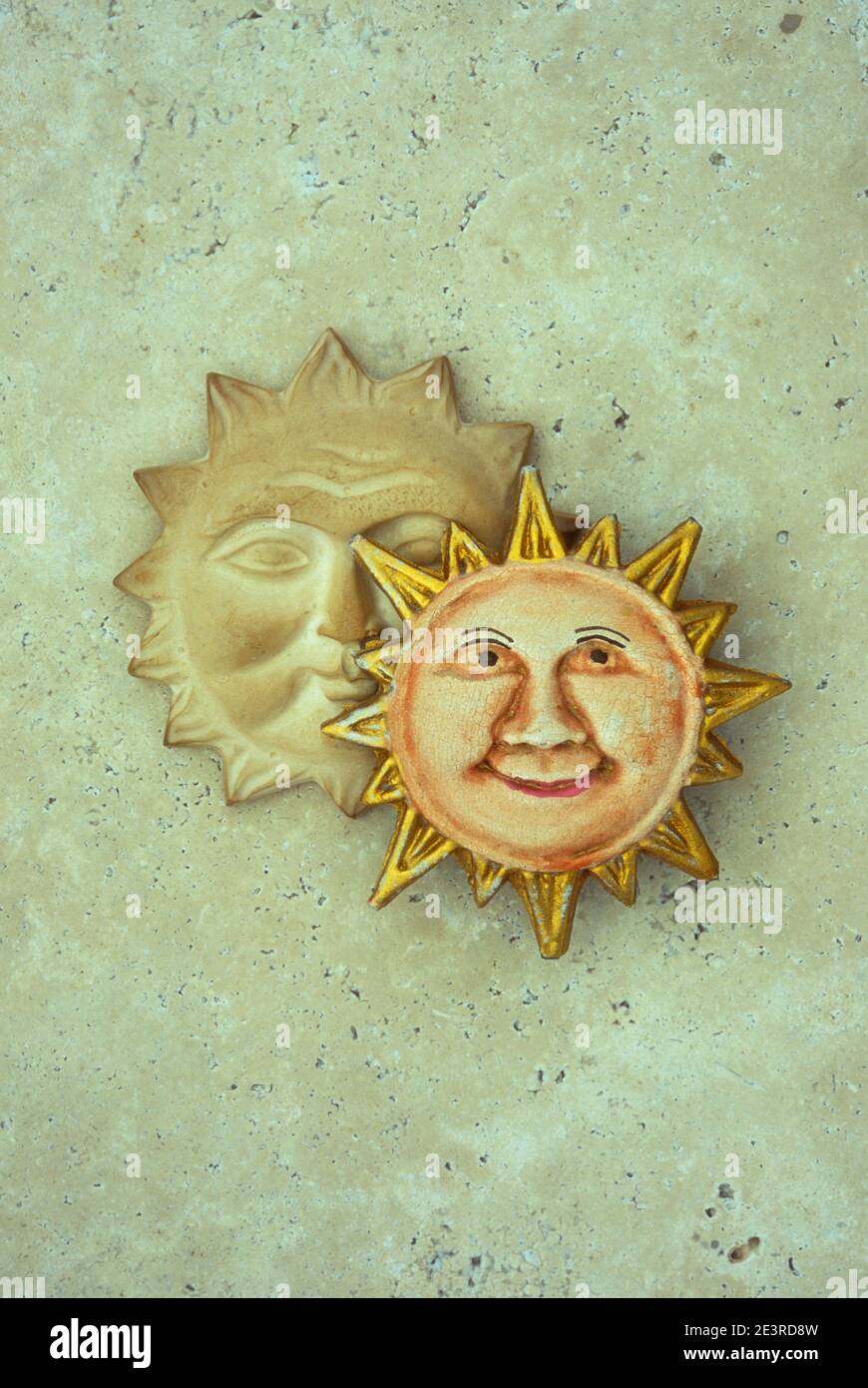 Modello in gesso di sole sorridente con faccia amichevole e molto altro il sole serio e oscuro dietro di esso Foto Stock