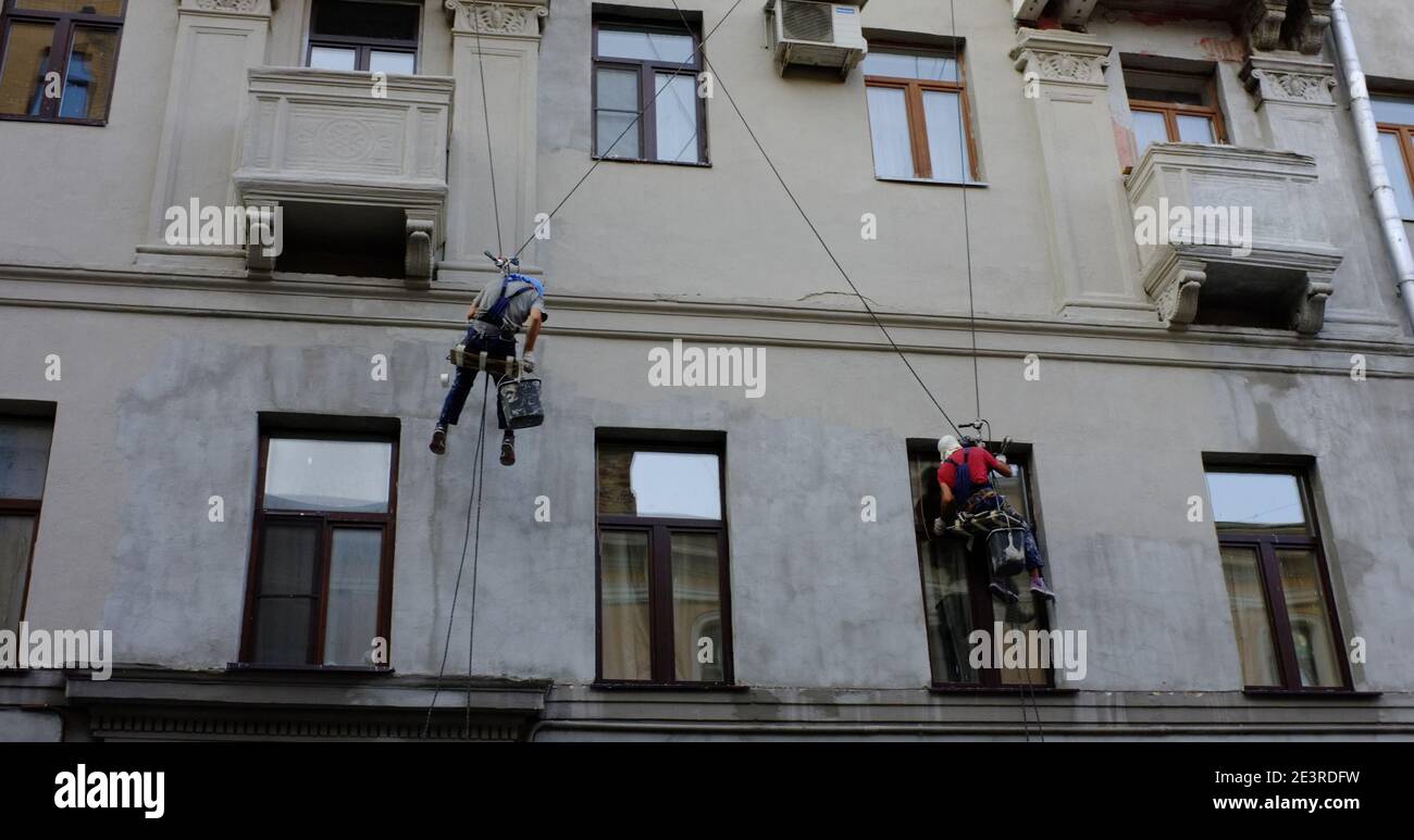 8 agosto 2013, Mosca, Russia. Gli scalatori industriali intonacano il muro di un edificio a Mosca. Foto Stock