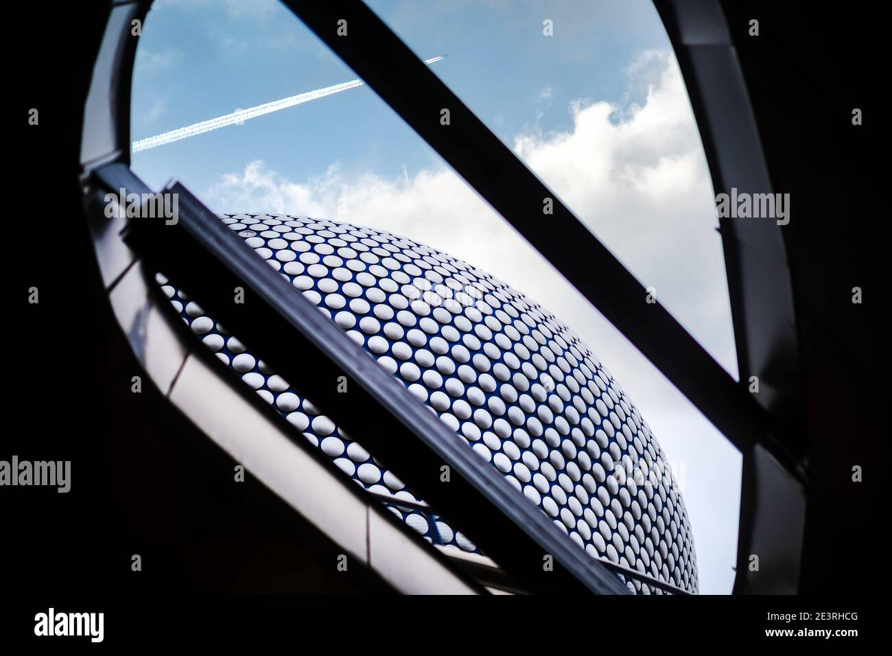 Birmingham UK Dicembre 2020 Centro commerciale Bullring guardando fino a. il cielo con le nuvole e l'aereo che sorvola l'architettura moderna con dischi in argento Foto Stock