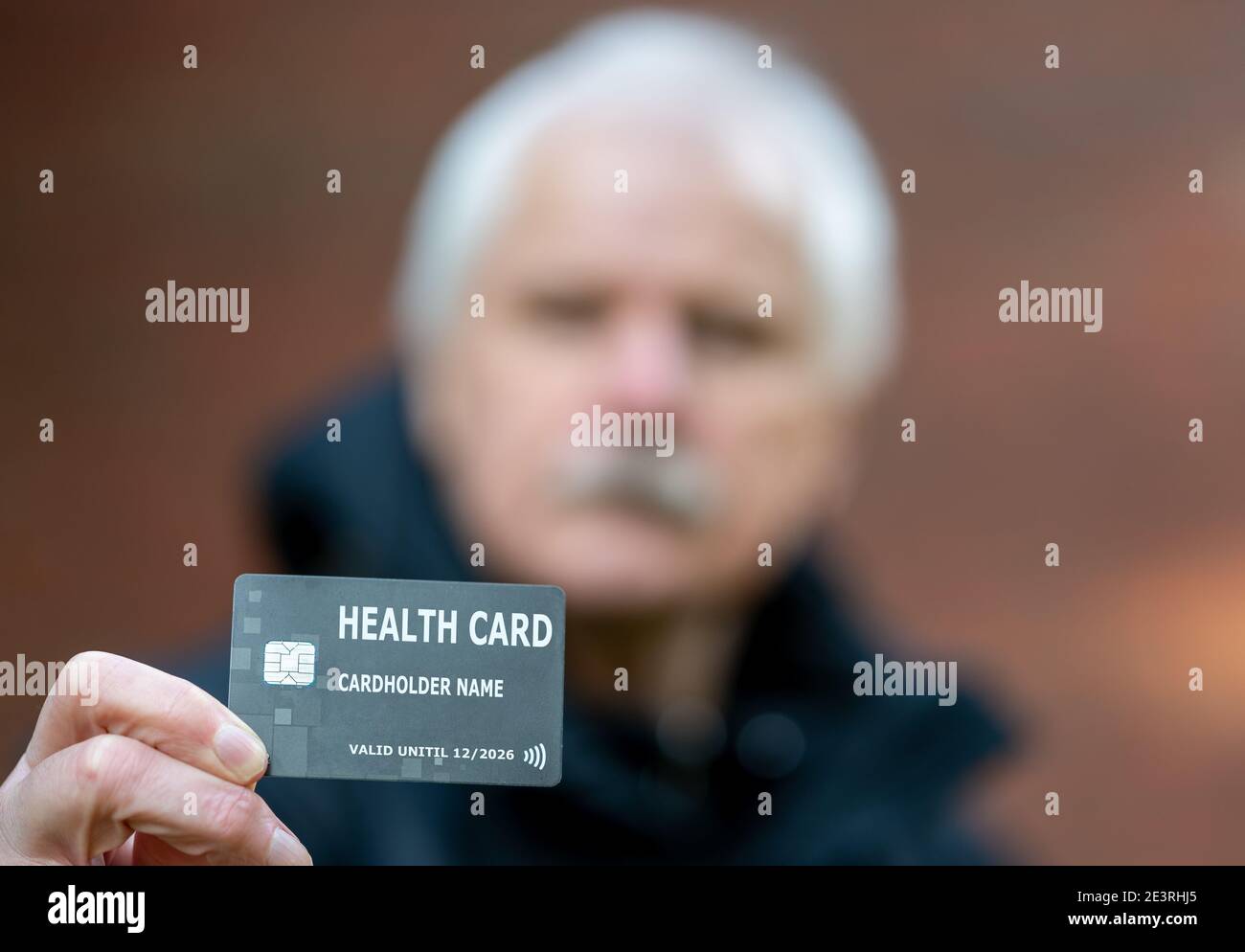 Anziano che mostra una scheda sanitaria digitale. Foto Stock