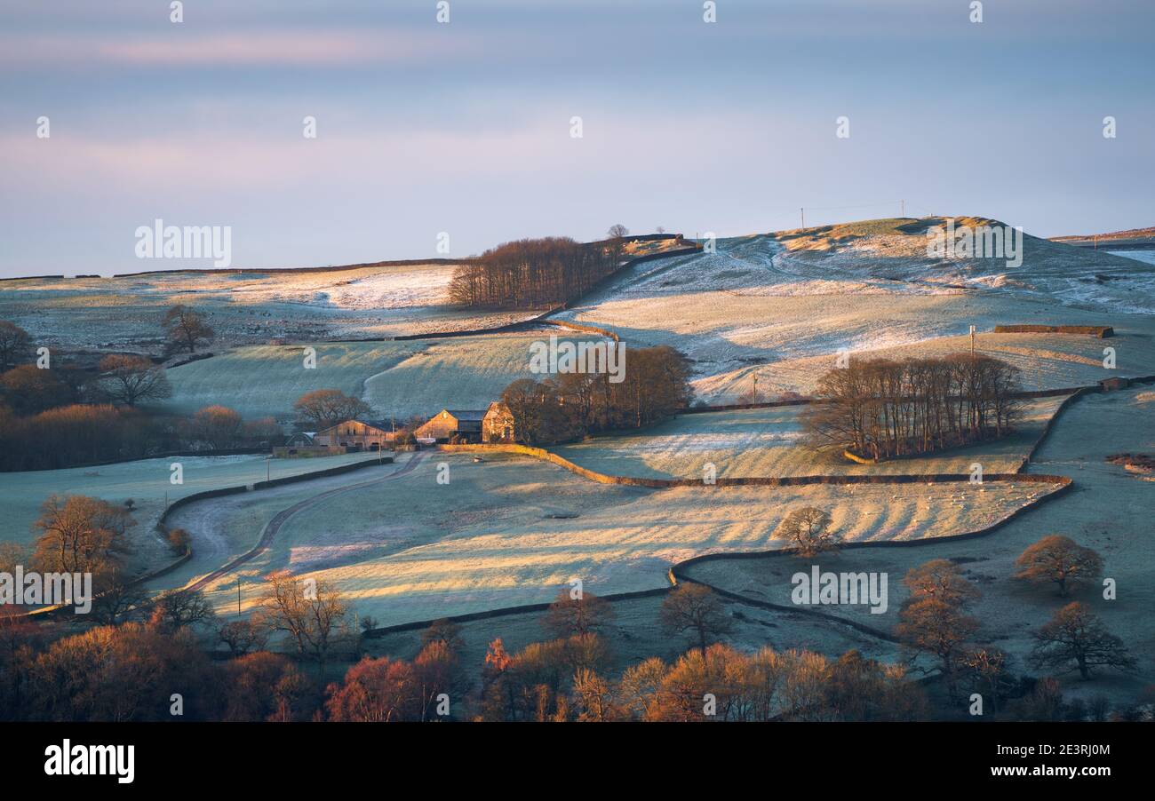 La prima luce diretta del sole che sorge evidenzia Hawpike Farm nelle Yorkshire Dales in una mattinata invernale amaramente fredda e gelida. Foto Stock