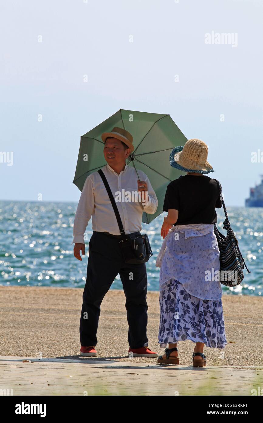 Persone asiatiche che camminano su una strada di mare a Salonicco Foto Stock