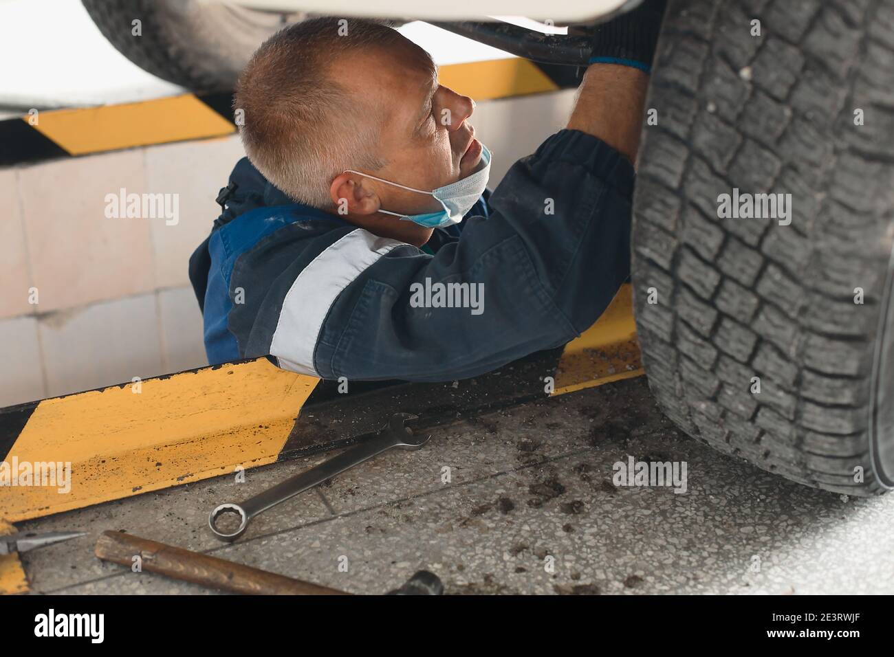 Un meccanico auto ripara un'auto. Un meccanico attento fa il lavoro Foto Stock