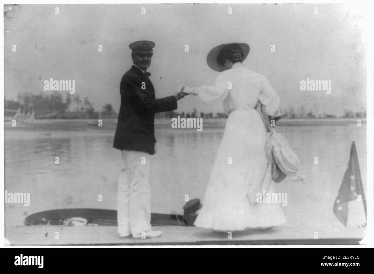 L'uomo ad assistere la donna in barca, Oyster Bay, Long Island, N.Y. Foto Stock