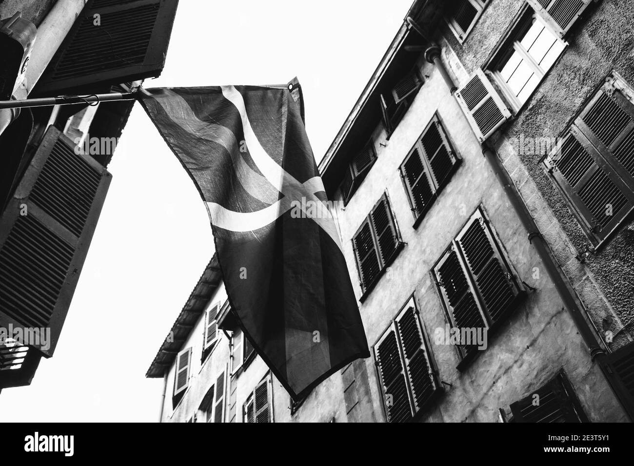 Bayonne, Francia. Sventolando la bandiera basca nella stretta strada della città vecchia. Foto storica in bianco e nero Foto Stock