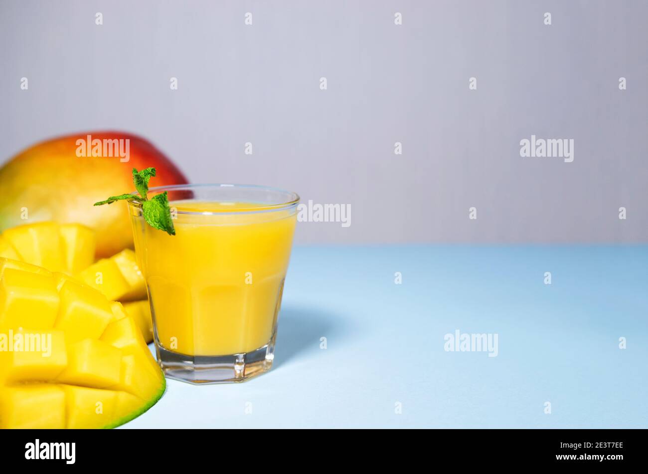 Mango Shake su sfondo blu. Sano bere Vitamina Smoothie. Succo fresco di frutta tropicale di mango. Spazio per testo, CopySpace. Cibo da dieting Foto Stock