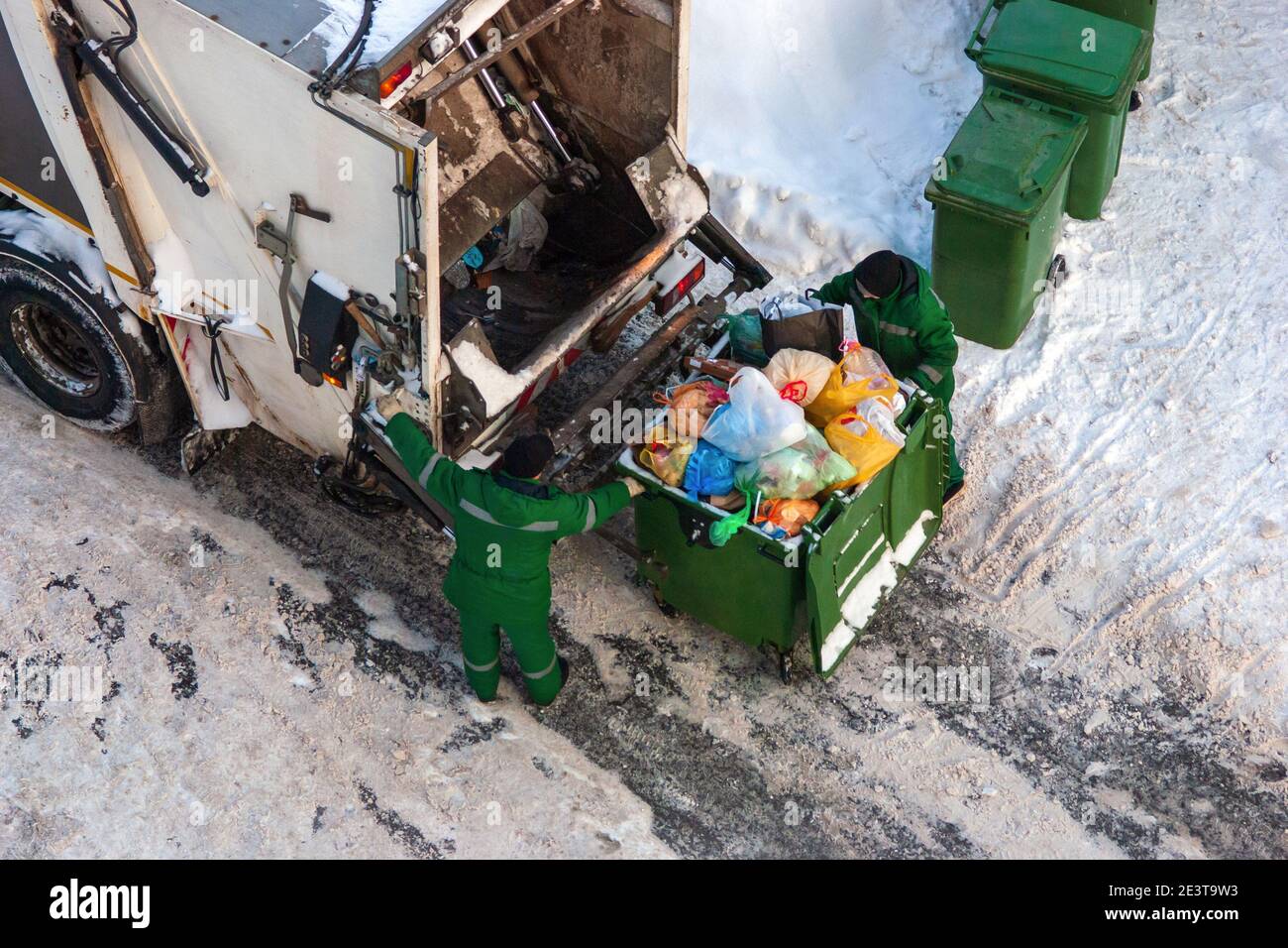 i lavoratori addetti alla raccolta dei rifiuti raccoliscono i rifiuti domestici in inverno Foto Stock