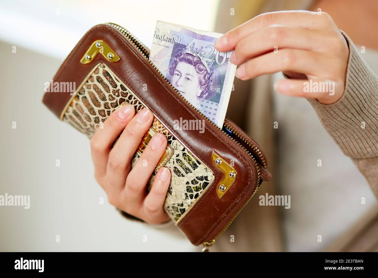 Donna che prende denaro dal suo borsone Foto Stock