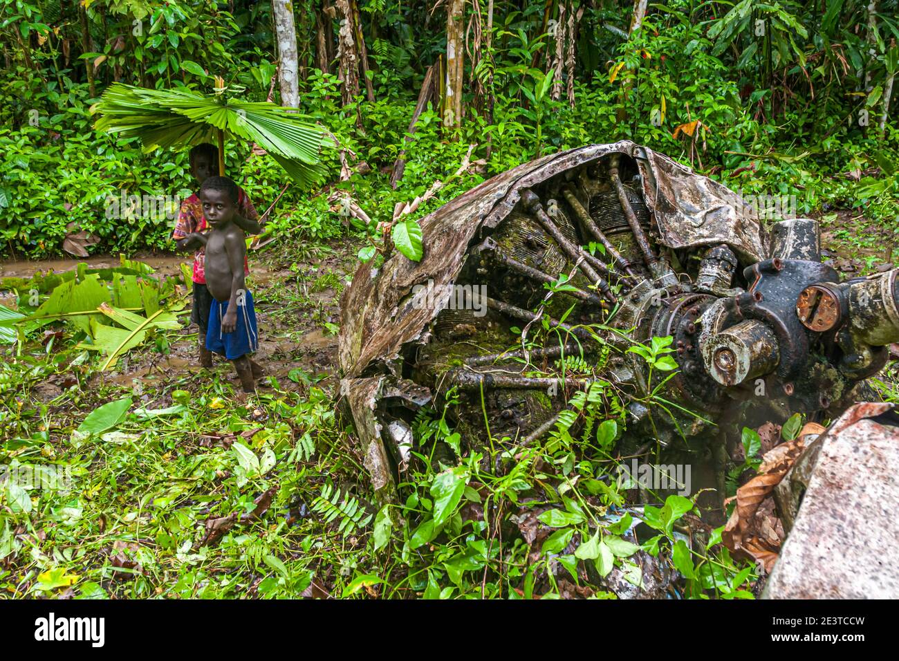 Due ragazzi con ombrelloni da pioggia fatti in proprio nella giungla di Bougainville Foto Stock
