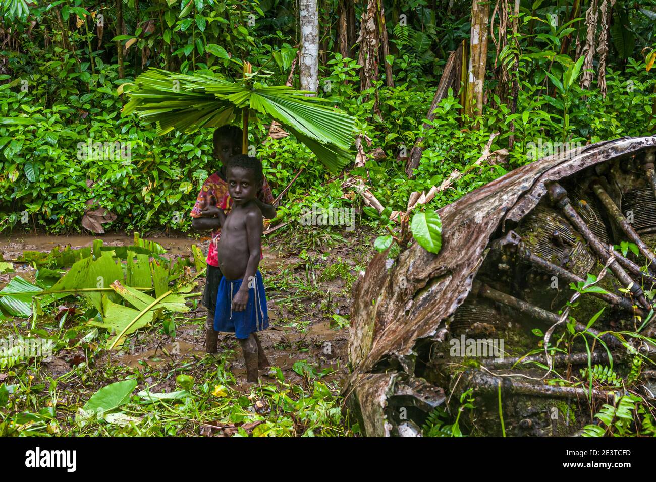Due ragazzi con ombrelloni da pioggia fatti in proprio nella giungla di Bougainville Foto Stock