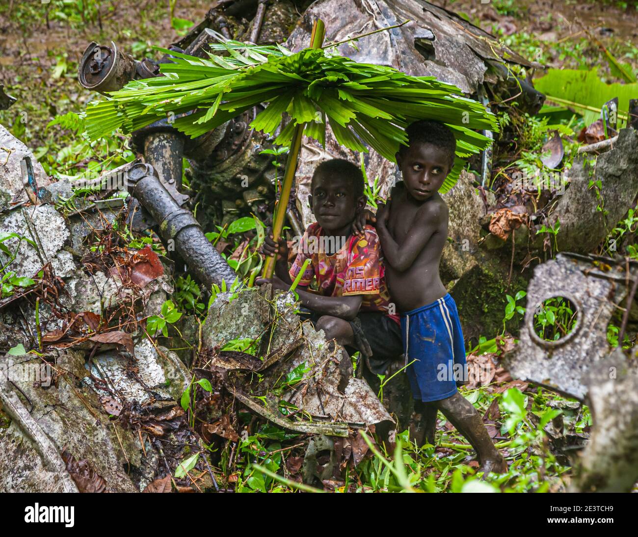 Due ragazzi con ombrelli da pioggia fatti in proprio nella giungla di Bougainville, Papua Nuova Guinea Foto Stock