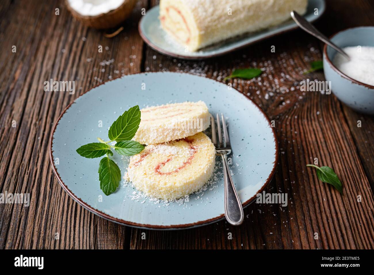 Delizioso dessert, involtini di cocco ripieni di vaniglia e crema al rum su rustico fondo di legno Foto Stock